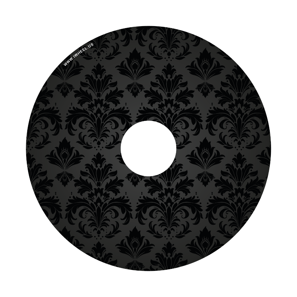 Close up picture of a wheelchair wheel cover, decorated with black damask patterns on a black background