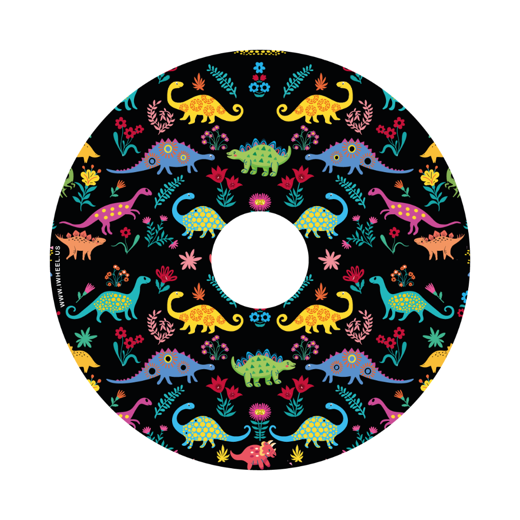 Close-up picture of a rear wheelchair wheel cover displaying cartoon-like, colorful dinosaurs on a black background.