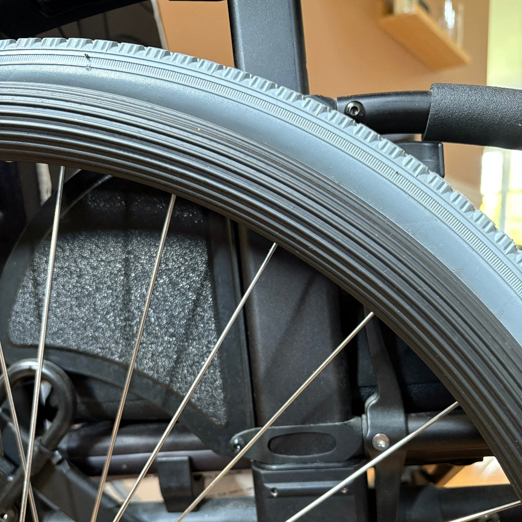 Detail of a black, grooved push rim cover.
